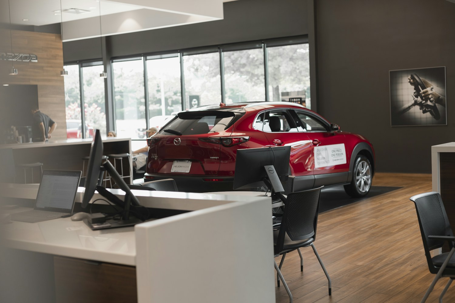 A red car inside a bright dealership showroom